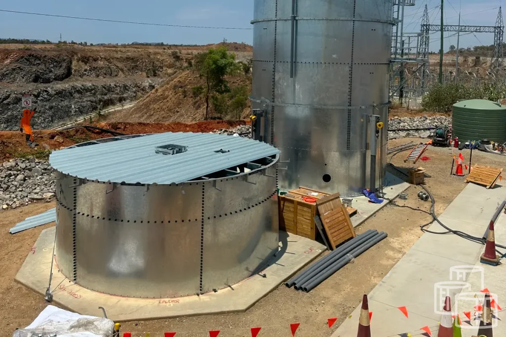 Construction team assembling modular steel panel tanks